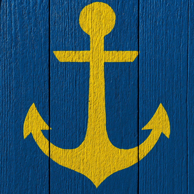 Yellow anchor symbol painted on a textured blue wooden surface, representing stability and grounding.