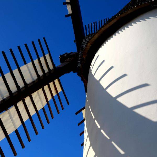 A peaceful windmill under a soft sky, symbolizing the calming rhythm of breath and nervous system regulation.