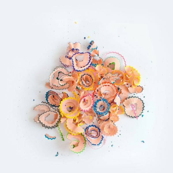 Colorful pencil shavings scattered on a white background, symbolizing mental clutter and the process of clearing overthinking loops