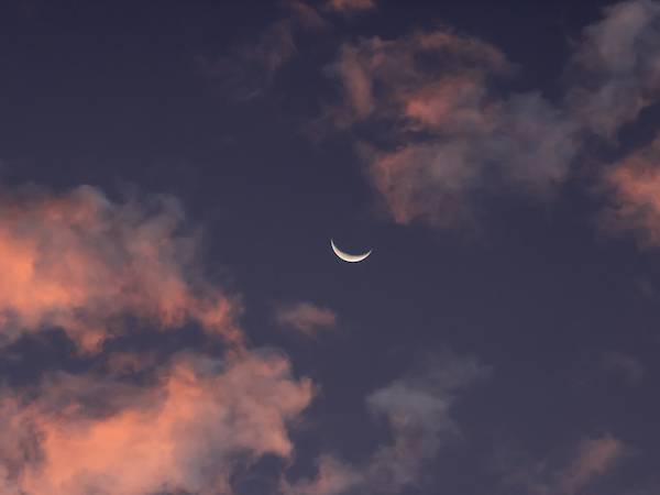 Crescent moon in a calm twilight sky, illustrating healthy sleep rhythms and the transition into nighttime rest.