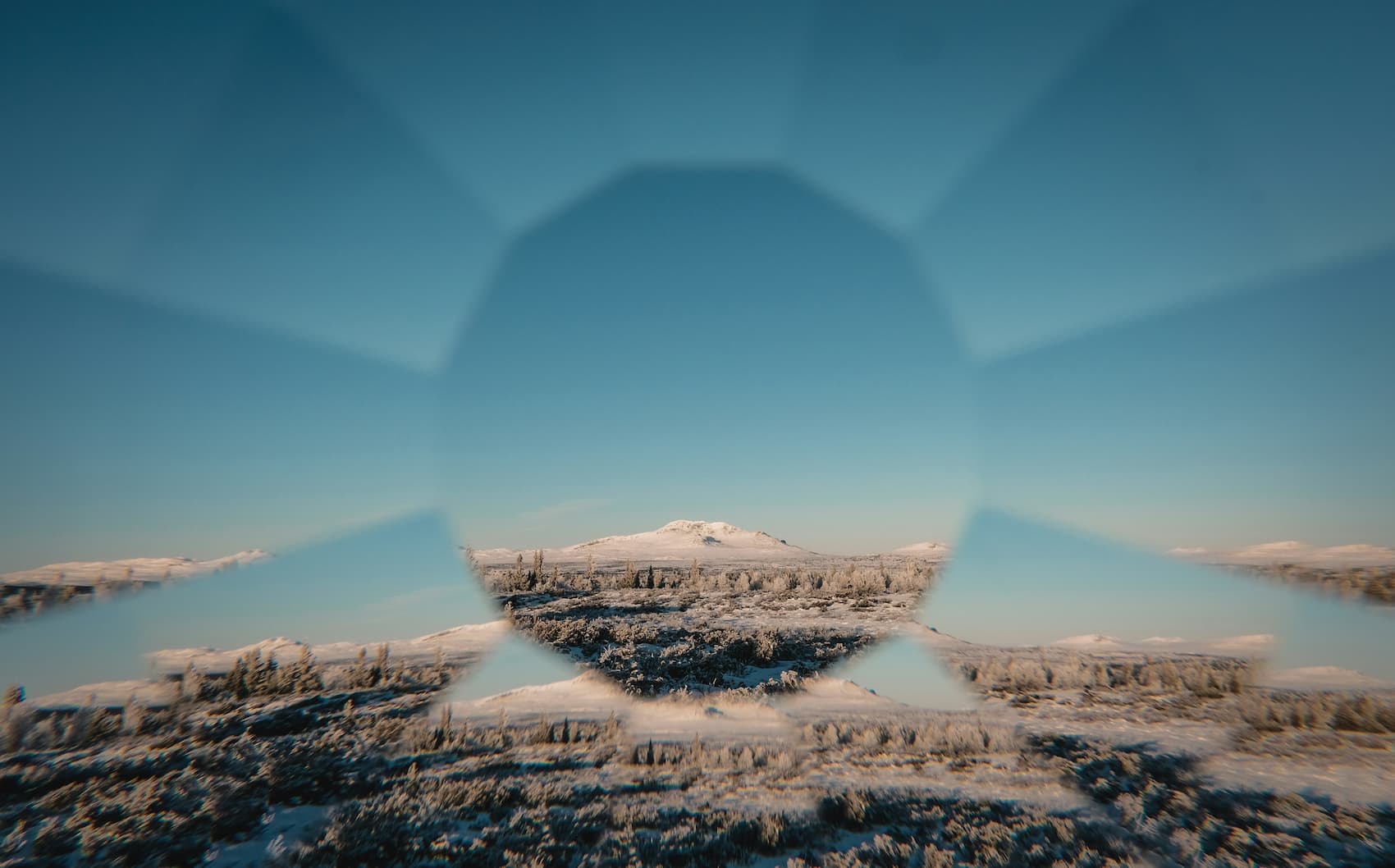 Mountain landscape viewed through a kaleidoscope-like lens, symbolizing curiosity, fresh perspectives, and approaching familiar experiences with Beginner's Mind.